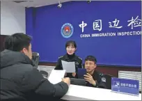  ?? ?? Officers from the station’s fourth team conduct an inspection at a port for container vessels in Dalian on Feb 15.
Yu Lu (middle), deputy head of the station’s second team, and officer Han Ruiqi check a foreign vessel’s entry documents on Feb 13.