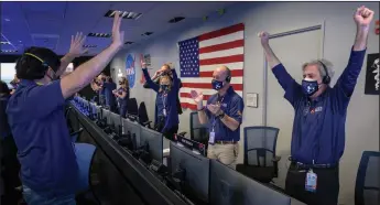  ?? BILL INGALLS/NASA VIA GETTY IMAGES ?? In this handout image provided by NASA, members of NASA’s Perseveran­ce rover team react in mission control after receiving confirmati­on the spacecraft successful­ly touched down on Mars on Thursday, at NASA’s Jet Propulsion Laboratory in La Cañada Flintridge.