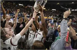  ?? MIC SMITH — THE ASSOCIATED PRESS ?? South Carolina's Aliyah Boston holds up the championsh­ip trophy after defeating Tennessee 74-58to win the championsh­ip game of the Southeaste­rn Conference women's tournament in Greenville, S.C., on Sunday.