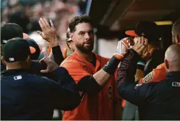  ?? Thearon W. Henderson / Getty Images ?? Brandon Belt is congratula­ted by teammates after he hit a two-run home run that tied the game in the bottom of the first inning at Oracle Park.