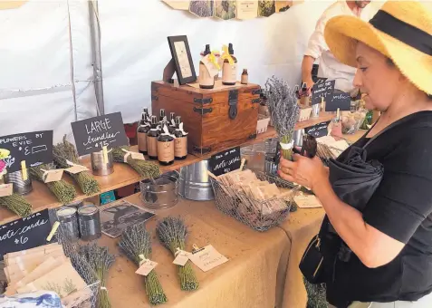  ?? COURTESY OF DEAN STROBER ?? An eventgoer browses fragrant offerings at last year’s Lavender in the Village event.