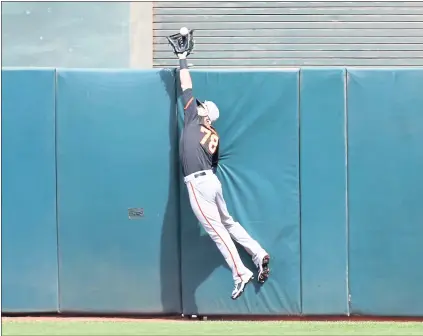  ?? NHAT V. MEYER — STAFF PHOTOGRAPH­ER ?? Giants outfielder Steven Duggar leaps to make a catch at the wall on a ball hit by Matt Joyce of the A’s in the third inning on Sunday.