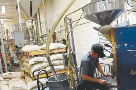  ?? RJ Sangosti, The Denver Post ?? Mick Davis works on a specially roasted coffee at Boyer’s Coffee on Wednesday in Denver. Last month, Boyer’s began supplying three exclusive blends of coffee to Walmart stores across the country, company officials said.