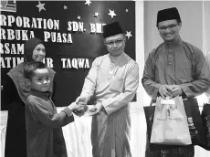  ??  ?? Harun presenting the Hari Raya goodies to one of the orphans.