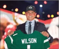  ?? Jeff Haynes / Associated Press ?? BYU quarterbac­k Zach Wilson holds a New York Jets jersey after being selected second overall by the team in the first round of the NFL draft in April.