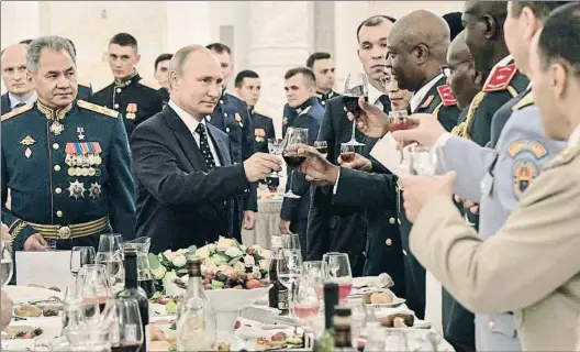  ?? ALEXÉI NIKOLSKI / AP ?? Pompa. Vladímir Putin brinda con los graduados de las academias militares rusas en el Kremlin, la semana pasada;
abajo, una bandera rusa