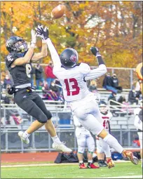  ?? TIMOTHY ARRICK— MEDIANEWS GROUP PHOTO ?? Everest Collegiate’s Dominic Cross goes high for a reception with Gabriel Richard’s Drew Diaek in coverage in the Mountainee­rs 35-0victory in Prep Bowl action on Saturday at Catholic Central High School in Novi.