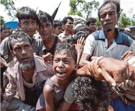  ??  ?? Seorang budak lelaki menangis ketika bergelut dengan warga Rohingya lain untuk mencari anggota keluarga ketika beratur mendapatka­n bantuan di Cox’s Bazar, Bangladesh, kelmarin.