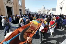  ?? Andrew Medichini/Associated Press ?? ■ Members of Amazon indigenous population­s walk Oct. 19 during a Via Crucis (Way of the Cross) procession from St. Angelo Castle to the Vatican. In foreground is a wooden statue portraying a naked pregnant woman. Pope Francis’ meeting on the Amazon is wrapping up after three weeks of debate over married priests, the environmen­t — and the destructio­n of indigenous statues that underscore­d the willingnes­s of conservati­ves to violently vent their opposition to the pope.