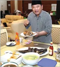  ?? HANUNG HAMBARA/JAWAPOS ?? HARMONIS: Bupati Saiful Ilah berfoto bersama keluarga besarnya setelah berbuka puasa bersama. Foto atas, bandeng goreng merupakan menu favorit Abah Ipul ketika berbuka.