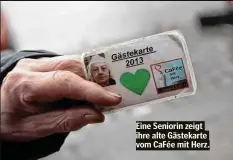  ??  ?? Eine Seniorin zeigt ihre alte Gästekarte vom CaFée mit Herz.