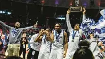  ?? VINCENT D. JOHNSON/DAILY SOUTHTOWN ?? EJ Horton holds up the trophy after Phillips beat Benton in the Class 2A state championsh­ip game at the State Farm Center in Champaign on Saturday.