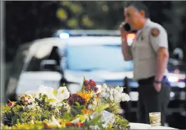  ?? Damian Dovarganes ?? The Associated Press file Flowers were left by mourners near the site of the Nov. 7 mass shooting at a country music bar in Thousand Oaks, Calif.