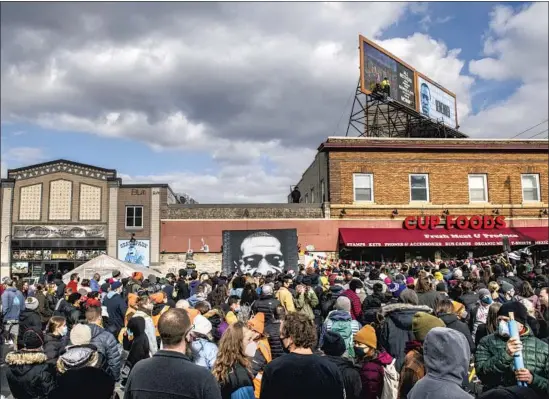  ?? Brandon Bell Getty Images ?? PEOPLE GATHER at 38th Street and Chicago Avenue in Minneapoli­s for the verdict. George Floyd was killed at this intersecti­on in May after a trip to Cup Foods.