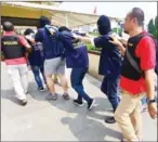  ?? FERNANDO/AFP ?? Police guard men arrested in a raid, during a press conference at a police station in Jakarta yesterday.