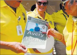  ?? Bridget Bennett ?? Las Vegas Review-journal Police volunteers Thursday read a poster for an event in remembranc­e of Avery Turner.