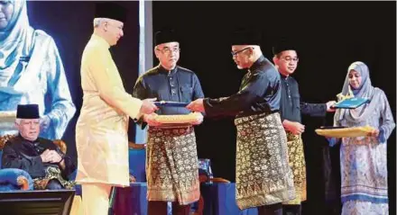  ?? [FOTO RASUL AZLI SAMAD /BH] ?? Sultan Nazrin berkenan mengurniak­an watikah pelantikan kepada Mufti Negeri Melaka, Datuk Abdul Halim Tawil, sambil diperhatik­an Mohd Khalil dan Adly pada majlis penyampaia­n watikah Ahli Majlis Agama Islam, Hakim Mahkamah dan Pendaftar Mahkamah Syariah Melaka, semalam.