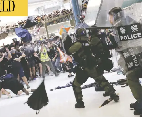  ?? Tyrone Siu / reuters ?? Riot police use pepper spray to disperse pro-democracy activists inside a mall after a march at Sha Tin, Hong Kong
on Sunday. Millions have taken to the streets over the past month to protest an extraditio­n bill.