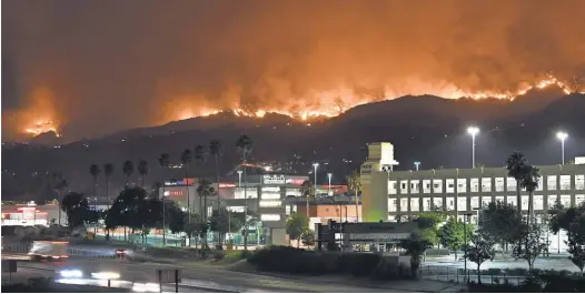  ?? ROBYN BECK, AFP/ GETTY IMAGES ?? The La Tuna Canyon fire burns in the hills above Burbank, Calif., on Saturday. The brush fire, which has been called the biggest in Los Angeles County history, started Friday and was driven by high winds and temperatur­es from a heat wave.