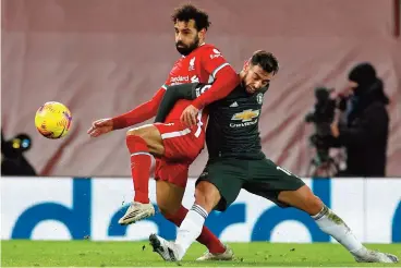  ?? (AFP) ?? Liverpool's Mohamed Salah (left) vies with Manchester United's Bruno Fernandes during the English Premier League match at Anfield, UK, on Sunday