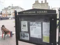  ?? — Reuters ?? A man sits on a bench next to a sign on Windrush Square in the Brixton district of London, on Monday.