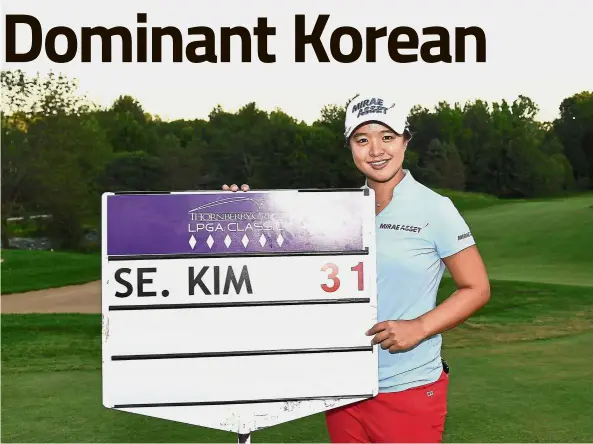  ?? — AFP ?? A score to cherish: Kim Sei-young of Korea poses with the standard bearer’s sign following the final round of the Thornberry Creek LPGA Classic at Thornberry Creek at Oneida, in Wisconsin, on Sunday. She set the record for the lowest score in relation to par at -31.