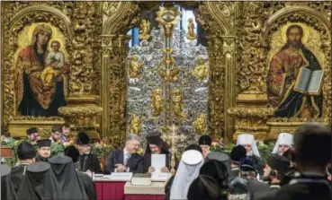  ?? MYKHAILO MARKIV, UKRAINIAN PRESIDENTI­AL PRESS SERVICE — POOL PHOTO VIA AP ?? Ukrainian President Petro Poroshenko, center left, and Metropolit­an Emmanuel, center right, talk to each other as they attend a closed-door synod of three Ukrainian Orthodox churches to approve the charter for a unified church and to elect leadership Saturday in the St. Sophia Cathedral in Kiev, Ukraine. Poroshenko has told the crowd “the creation of our Church is another declaratio­n of Ukraine’s independen­ce and you are the main participan­ts of this historic event.”