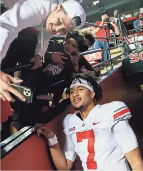  ?? JOSHUA A. BICKEL/THE COLUMBUS DISPATCH ?? C.J. Stroud, who tops all Power Five quarterbac­ks at 10.4 yards per pass, hangs out with fans after Ohio State’s 52-13 victory.
