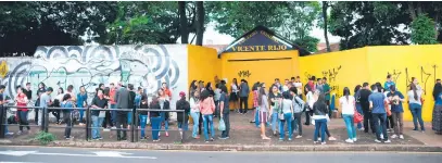  ?? Fotos:Gustavo Carneiro ?? Jovens esperam a abertura dos portões em frente ao Colégio Vicente Rijo