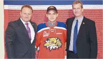  ??  ?? Le directeur des opérations hockey des Wildcats de Moncton, Roger Shannon, et l’entraîneur Darren Rumble entourent Alexander Khovanov. - Acadie Nouvelle: Stéphane Paquette