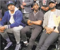  ?? AP ?? From left, Carmelo Anthony, Chris Paul and LeBron James watch during the first half last night as the Nets beat the Heat. The three were watching Dwyane Wade play the final NBA game of his career.