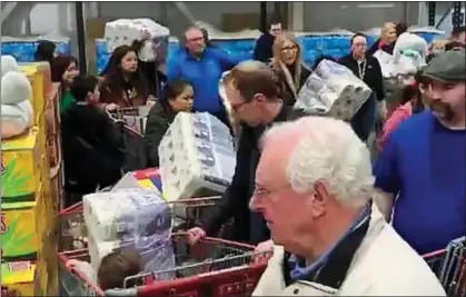  ??  ?? STOCKING UP: Frantic shoppers strip the shelves of essentials at a Costco supermarke­t in Farnboroug­h yesterday