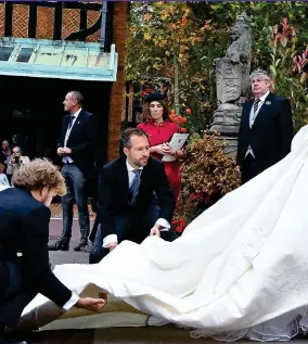  ??  ?? Final touches: Designers Christophe­r De Vos and Peter Pilotto adjust Eugenie’s dress before she enters St George’s Chapel