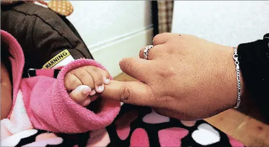  ?? PICTURES: DIMPHO MAJA/AFRICAN NEWS AGENCY (ANA) ?? A baby grasps a caring hand at El-shammah Home for abandoned babies in Primrose, Germiston.