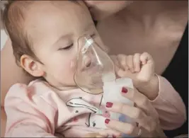  ?? ADOBE STOCK PHOTO ?? A baby inhaling from the inhaler.