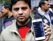  ?? REUTERS ?? An Uber taxi driver shows an applicatio­n software in his mobile phone used to track the taxi’s location, in New Delhi in December 2014.