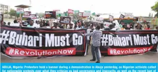  ?? —AFP ?? ABUJA, Nigeria: Protesters hold a banner during a demonstrat­ion in Abuja yesterday, as Nigerian activists called for nationwide protests over what they criticize as bad governance and insecurity, as well as the recent ban of US social media platform Twitter by the government of President Muhammadu Buhari.