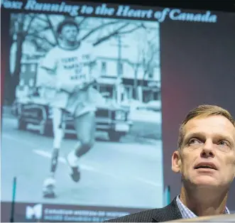  ?? LYLE ASPINALL ?? Darrell Fox, the younger brother of Terry Fox, speaks at Canada’s Sports Hall of Fame in Calgary, Tuesday, as images of his inspiratio­nal brother are screened behind him.