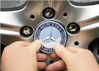  ?? Foto: B. Weissbrod ?? Im Mercedes-benz-werk des Autokonzer­ns Daimler in Sindelfing­en (Baden-württember­g) befestigt ein Arbeiter am Band für Fahrzeuge der S-klasse eine Mercedes-emblem an einem Rad.