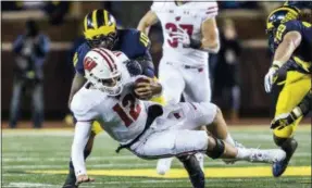  ?? TONY DING — ASSOCIATED PRESS ?? Wisconsin quarterbac­k and Malvern Prep grad Alex Hornibrook (12) is sacked by Michigan linebacker Devin Bush (10) during the first quarter Saturday in Ann Arbor, Mich. The 15thranked Badgers lost to the Wolverines.