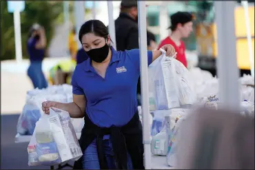  ?? GREGORY BULL / ASSOCIATED PRESS ?? A volunteer loads food into a car Oct. 28 at an Armed Services YMCA food distributi­on in San Diego.