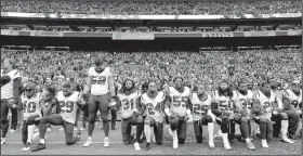  ?? AP file photo ?? kneel and stand during the singing of the national anthem before a game against the Seattle Seahawks last season. The NFL Players Associatio­n filed a grievance with the league Tuesday challengin­g the national anthem policy, saying the league imposed...