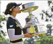  ?? Terrance Williams / Associated Press ?? In Gee Chun, of South Korea, kisses the winners trophy, after winning the KPMG Women’s PGA Championsh­ip golf tournament Sunday at Congressio­nal Country Club in Bethesda, Md.