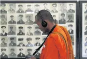  ?? REUTERS ?? A Buddhist monk looks at pictures of victims of the Khmer Rouge regime at Tuol Sleng Genocide Museum in Phnom Penh.