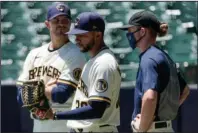  ?? The Associated Press ?? KEEPING IT COMPETITIV­E: Milwaukee Brewers’ Justin Grimm, Devin Williams and Josh Hader watch during a practice session Monday at Miller Park in Milwaukee.