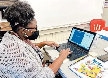  ?? BILL GRAHAM/THE MERIDIAN STAR ?? Teacher Jymeka Johnson logs onto a Zoom session last month at Poplar Springs Elementary School in Meridian, Miss.