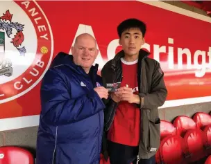  ??  ?? Accrington Stanley fan Jung Min Yoo travels 5,440 miles from South Korea to watch his beloved club. Pictured with