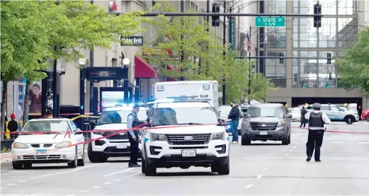  ?? PAT NABONG/SUN-TIMES ?? Police officers on May 15 respond to a shooting scene in a parking garage in the River North neighborho­od.