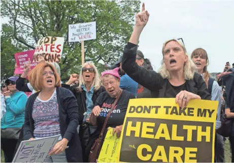  ?? NICHOLAS KAMM, AFP/GETTY IMAGES ?? Protesters shout at lawmakers walking out of the U.S. Capitol in Washington on Thursday after the House of Representa­tives narrowly passed a Republican proposal to repeal and replace Obamacare, delivering a welcome victory for President Trump.