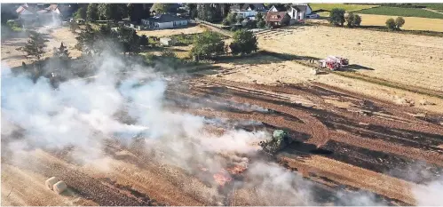  ?? FOTO: UWE HELDENS ?? In Hückelhove­n-Hilfarth brannte am Montag eine Strohballe­npresse aus und setzte ein Feld in Flammen.